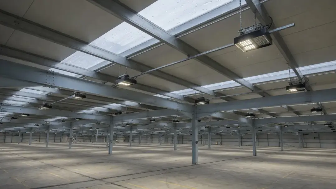 Interior of a warehouse looking up at the metal roof, steel portal frame and roof lights